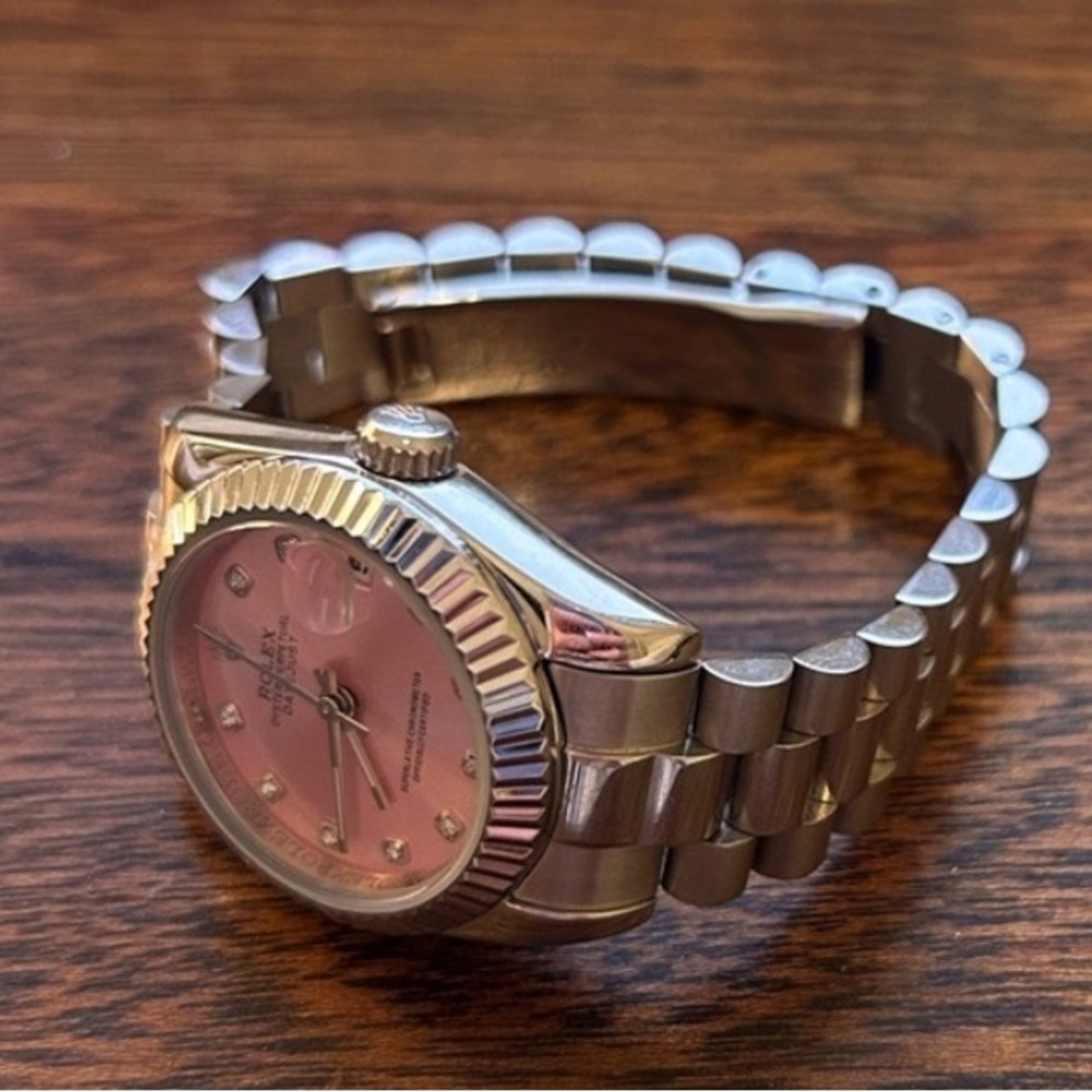 Elegant silver watch with pink face.